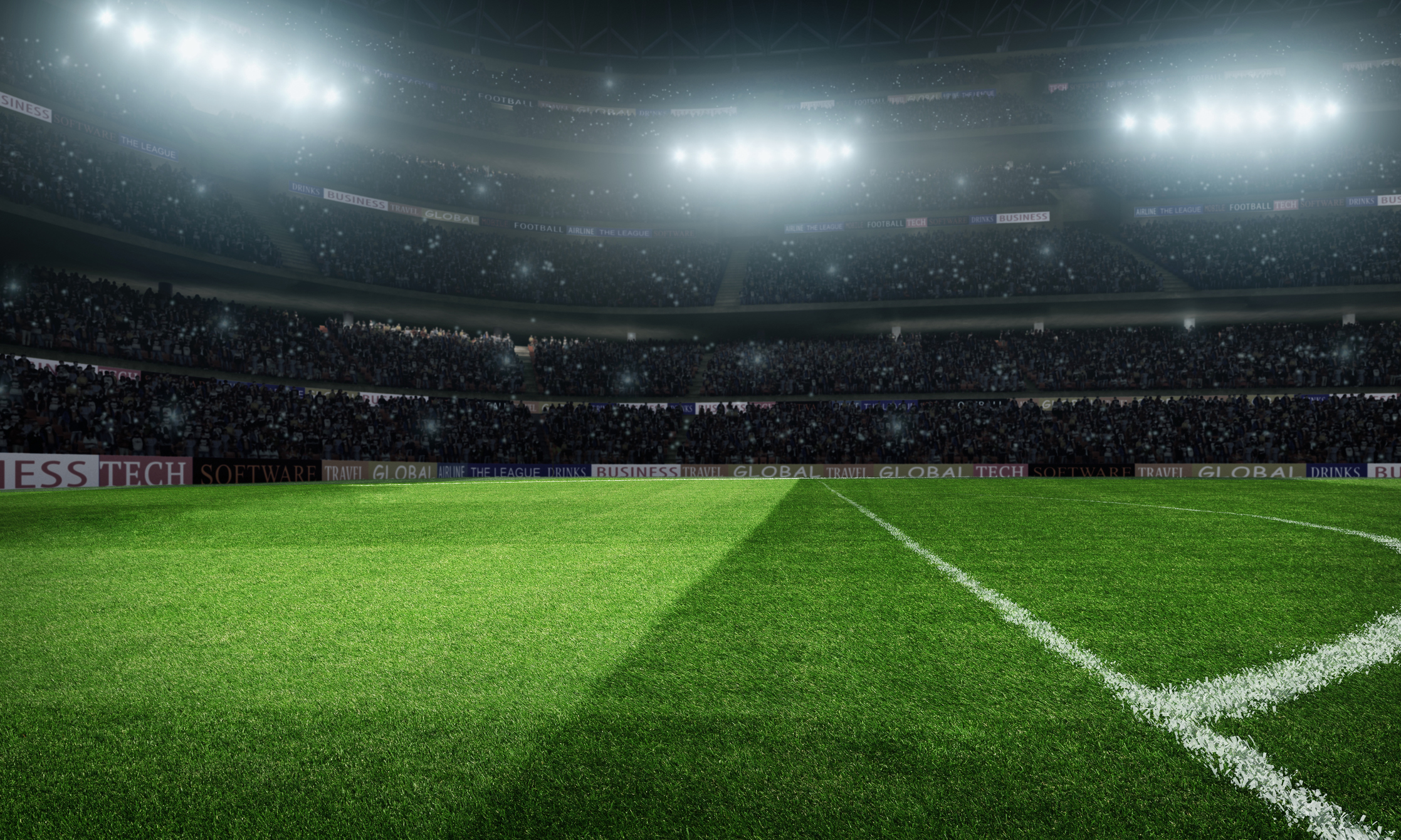 Outdoor floodlit stadium full of spectators under stormy evening sky